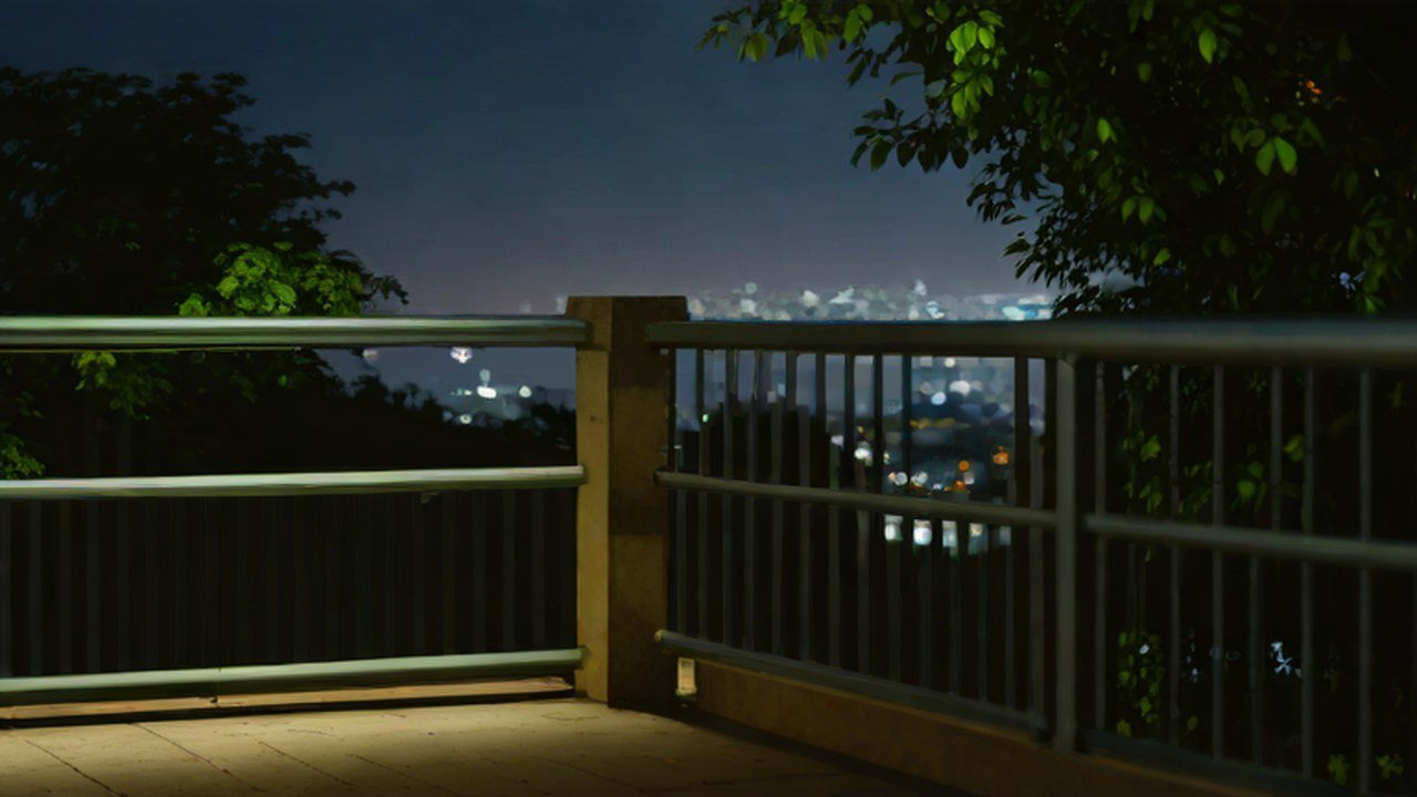 夜の展望スポットの柵と街の灯り